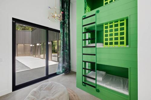 a green wall with a window in a bedroom at Owlwood by Juniper Holiday + Home in Harbert