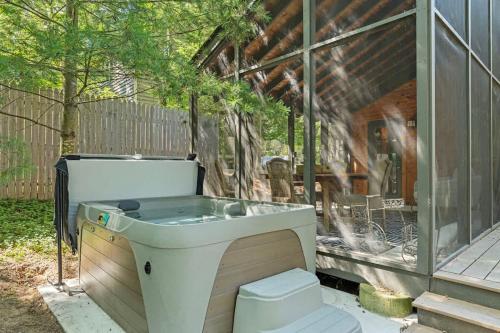 a bath tub sitting next to a glass house at Meadow Pines by Juniper Holiday + Home in Michigan City