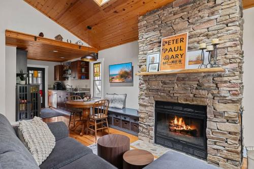 a living room with a stone fireplace and a table at Meadow Pines by Juniper Holiday + Home in Michigan City