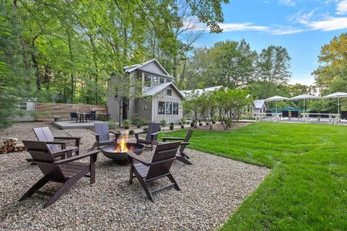 a backyard with a fire pit and chairs and a house at Townie 4 - The Fern by Juniper Holiday + Home in Union Pier