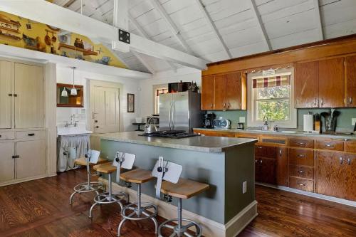 a kitchen with wooden cabinets and a island with bar stools at The Fourth Oak by Juniper Holiday + Home in Three Oaks
