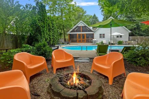 a backyard with chairs and a fire pit and a pool at Casa Azur by Juniper Holiday + Home in Union Pier