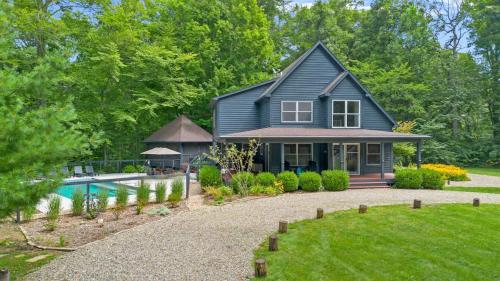 a black house with a swimming pool in a yard at Gray Haven by Juniper Holiday + Home in Union Pier