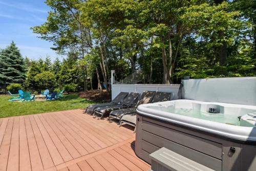 a bath tub sitting on a patio with chairs at Main Destination by Juniper Holiday + Home in Grand Beach