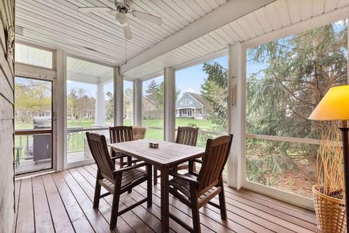 a dining room with a table and chairs on a porch at Schoolhouse Rock by Juniper Holiday + Home in New Buffalo