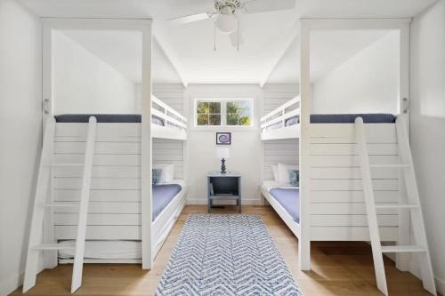 a bedroom with two bunk beds with a window at Greystone Cottage by Juniper Holiday + Home in Union Pier