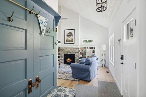 a living room with a blue door and a fireplace at Greystone Cottage by Juniper Holiday + Home in Union Pier
