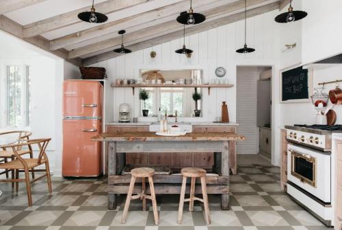 a kitchen with an old refrigerator and two stools at Leo Cottage by Juniper Holiday + Home in Union Pier