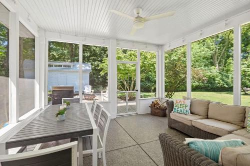 a screened in porch with a couch and a table at Whispering Arbor by Juniper Holiday + Home in Lakeside
