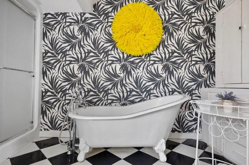 a bathroom with a white tub and a black and white wallpaper at Rabbit Run by Juniper Holiday + Home in Sawyer