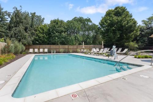 a swimming pool with lounge chairs around it at The Happy Place by Juniper Holiday + Home in Union Pier