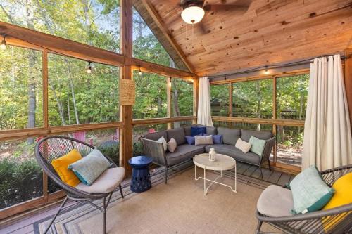 a screened in porch with a couch and chairs at Blue Beech Cottage in Union Pier