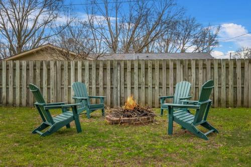 three green chairs sitting around a fire in a yard at Golden Crest Getaway in Stevensville