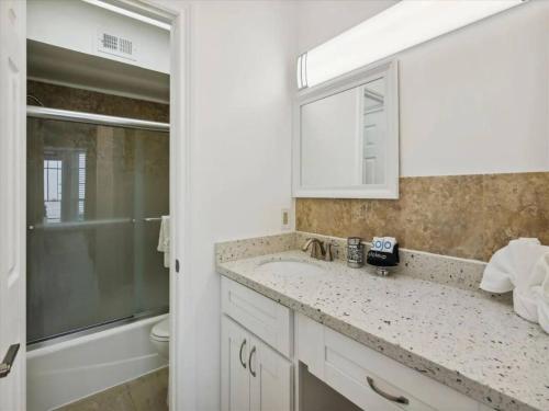 a bathroom with a sink and a toilet and a mirror at Ocean Front Condo - 3 Bdrms - Hot Tubs - 2 Pools - Gym - Tennis ct - SS2203 in Galveston