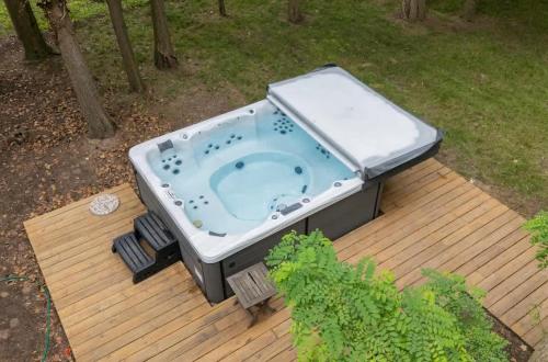 a hot tub sitting on top of a wooden deck at La Maison du Lac in Sawyer