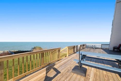 a wooden deck with a bench on the beach at Leilas Chalet in Stevensville
