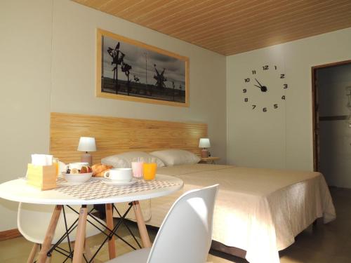 a bedroom with a bed and a table and a clock at Jardines Inn in Trinidad