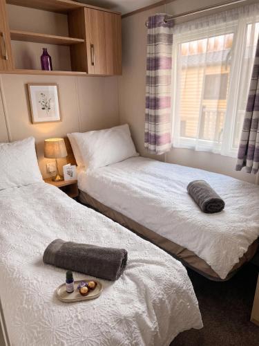 a bedroom with two beds and a window at 2 Bedroom Lakeview Lodge - Ensuite & Balcony Deck in Carnforth