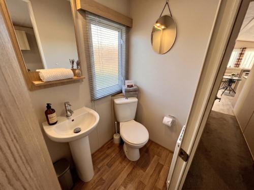 a small bathroom with a toilet and a sink at 2 Bedroom Lakeview Lodge - Ensuite & Balcony Deck in Carnforth