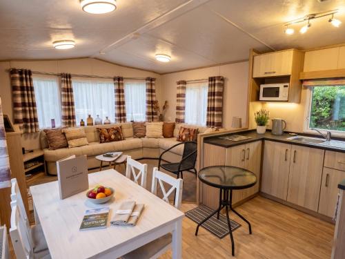 a kitchen and a living room with a table and chairs at 2 Bedroom Lakeview Lodge - Ensuite & Balcony Deck in Carnforth