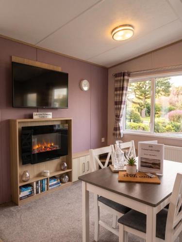 a living room with a table and a fireplace at 2 Bedroom Lakeview Lodge - Ensuite & Balcony Deck in Carnforth