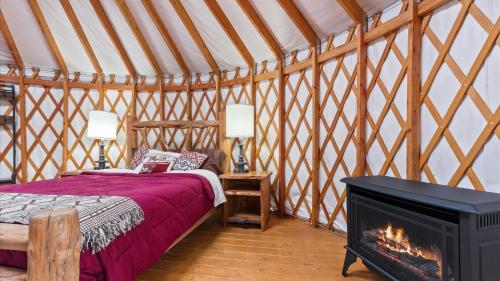 a bedroom with a bed and a fireplace in a yurt at Yurt 2 - The Gold Miner in Idaho City