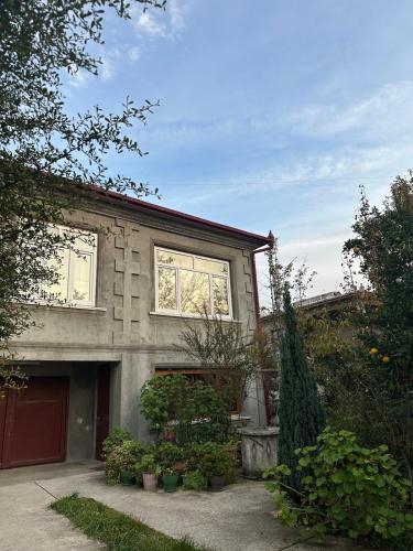 a house with a garage and some plants at Maryams Studio Guesthouse in Zugdidi