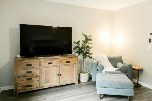 a living room with a television on a wooden dresser at Perfect Small Family Beach Condo in Saint Simons Island