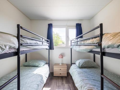 two bunk beds in a room with a window at Sluisje 15 in Kuinre
