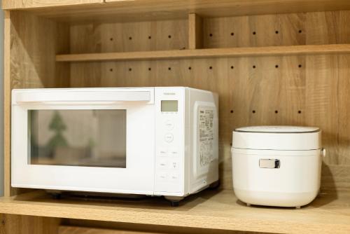 a white microwave sitting on a shelf next to a appliance at Goen Little hatchi 子供が喜ぶ隠れ家宿 in Iwaki