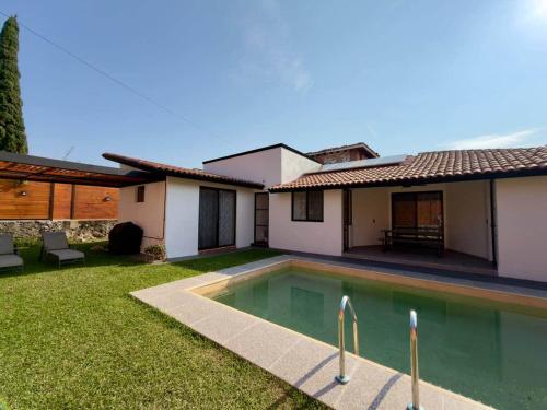 a house with a swimming pool in the yard at Casa a una cuadra del centro comercial in Oaxtepec