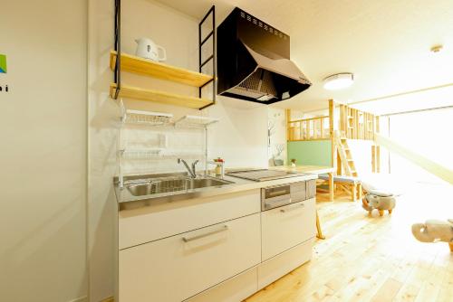 a kitchen with white cabinets and a sink at Goen Little hatchi 子供が喜ぶ隠れ家宿 in Iwaki