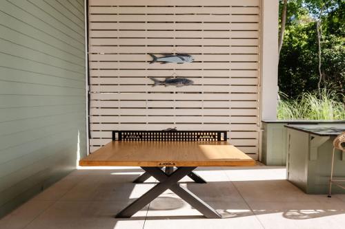 a picnic table in front of a wall with a window at Modern Coastal Home with Heated Pool in Bay Saint Louis