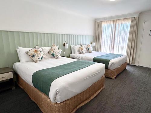 a hotel room with two beds and a window at Bathurst Motor Inn in Bathurst