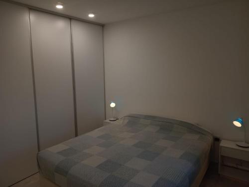 a bedroom with a checkered bed and two lamps at Bernal Alquileres in Viedma