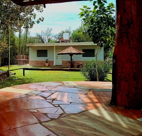 a patio with an umbrella in front of a house at cabaña huguito y vane in Tinogasta