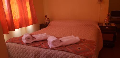 a bedroom with a bed with two towels on it at Hotel Frontera in La Quiaca