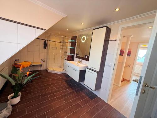 a bathroom with a staircase with a sink and a mirror at Villa del Sol in Büsum