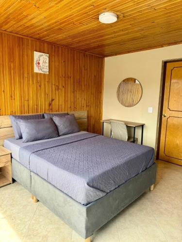 a bedroom with a bed and a wooden wall at Hostelfc Movistar57 in Bogotá
