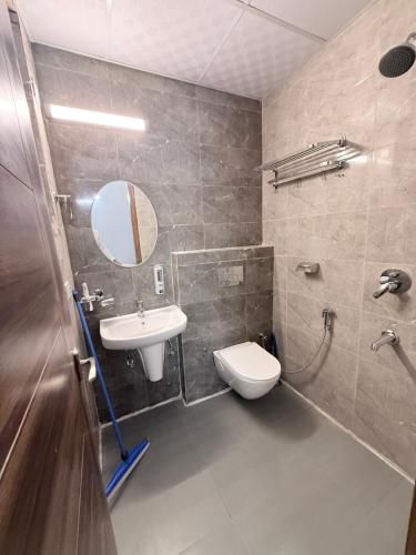 a bathroom with a sink and a toilet and a mirror at Skypod13 in Chandīgarh