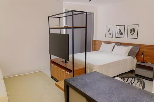 a bedroom with a bed and a tv in a room at Studio Moderno com Internet e Garagem. in Três Corações