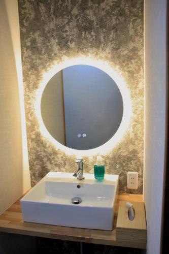 a bathroom with a white sink and a mirror at SAKADONEguesthouse in Iijima
