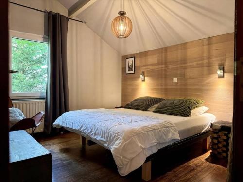 a bedroom with a large bed and a window at Cozy Durbuy Chalet with fireplace in Dochamps