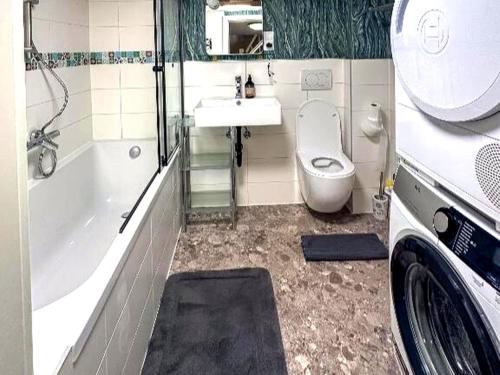 a bathroom with a toilet and a tub and a sink at Holiday Home in Konz in Konz
