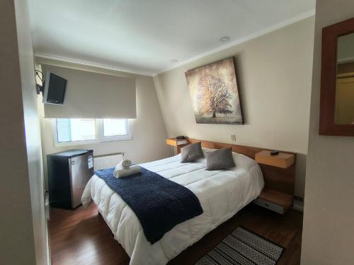 a bedroom with a bed and a painting on the wall at Hotel Ágora in Viña del Mar