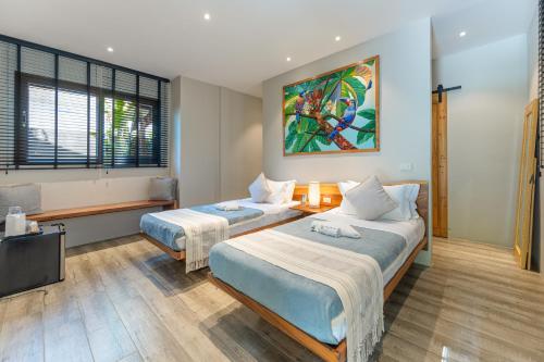 a hotel room with two beds and a television at Kajali Siargao in General Luna