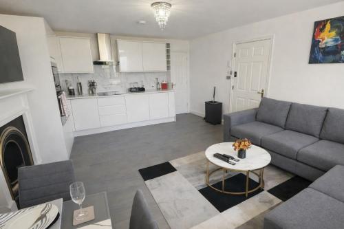 a living room with a couch and a table at Entire Apartment hosted by Pius in Redhill