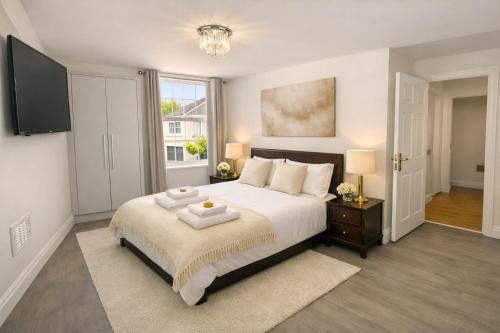 a bedroom with a large white bed with two towels on it at Entire Apartment hosted by Pius in Redhill