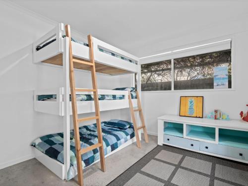 a bunk bed room with two bunk beds and a ladder at Esplanade Escape in Indented Head