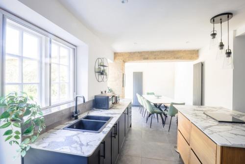 a kitchen with a sink and a large window at 5 bed central home- beautiful modern in Witney